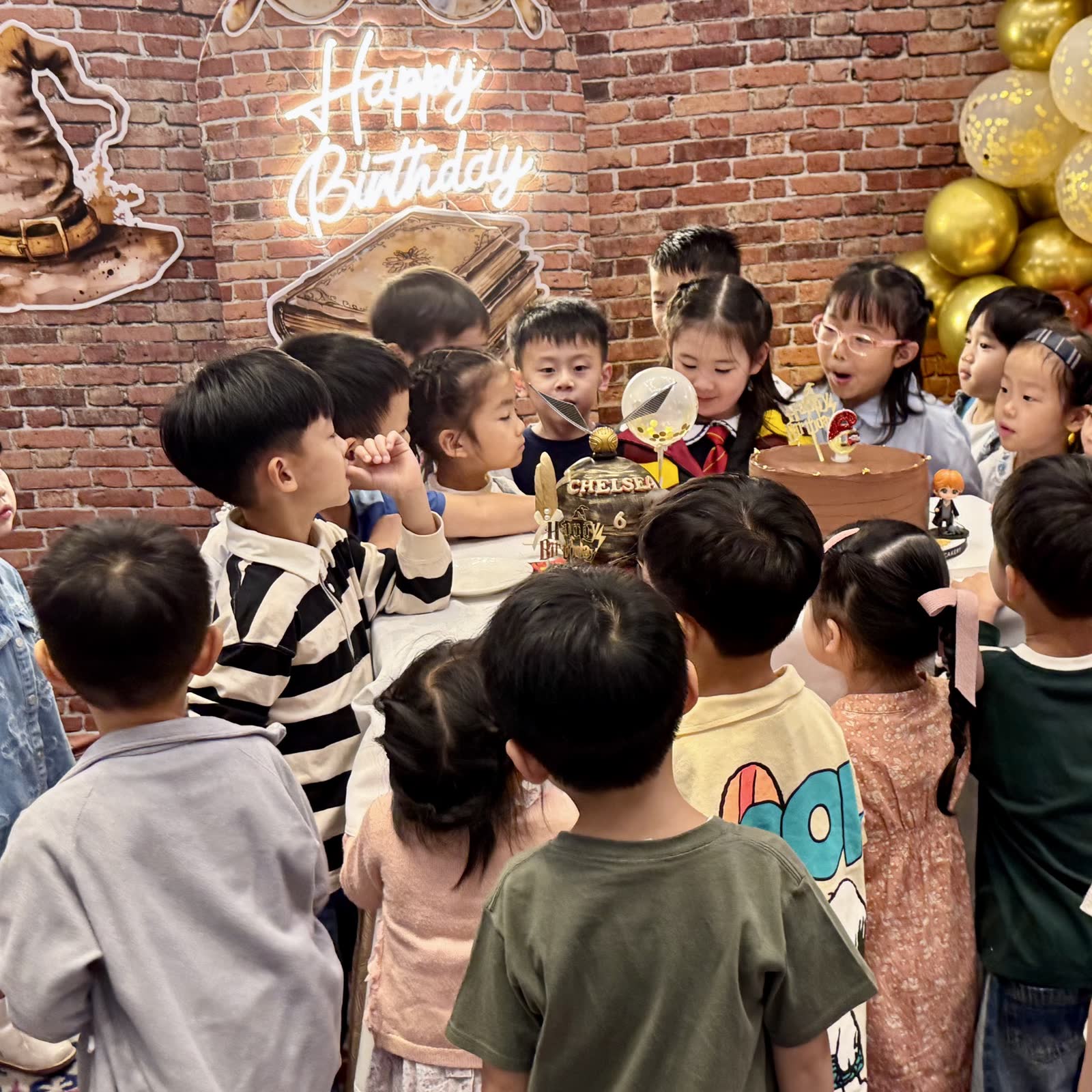 Children gathered around the birthday cake at a wizard-themed Newtonshow party