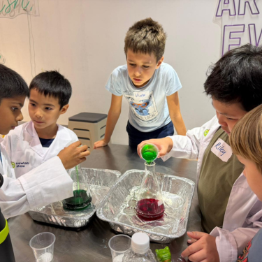 Children gathered around a colourful chemistry experiment at a Newtonshow kids' science camp