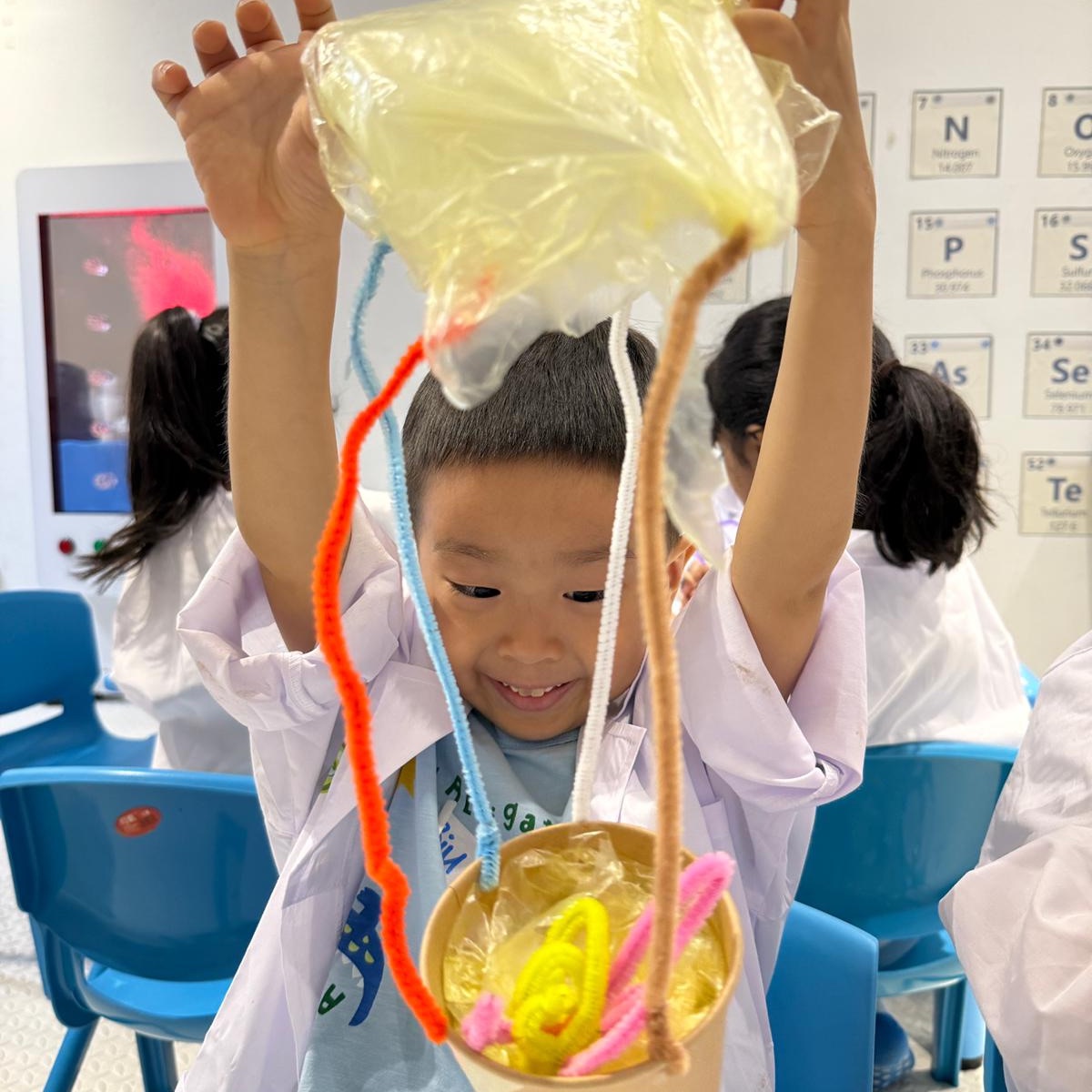 Child holding up the hot-air-balloon model he built at a Newtonshow camp