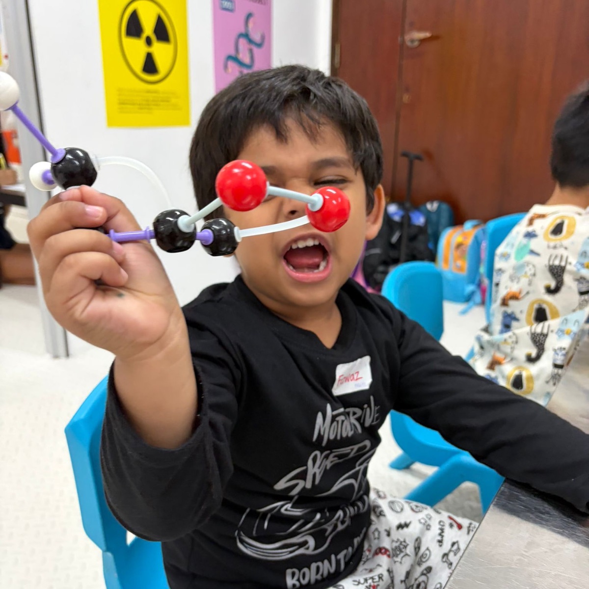Boy holding up the molecular model he built at a Newtonshow camp
